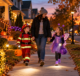Parent and children walking safely on a suburban sidewalk in Halloween costumes