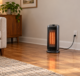 Electric space heater on a clear hardwood floor with its cord plugged directly into a wall outlet