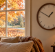Analog clock by an autumn window as daylight saving time ends