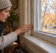Homeowner checking a draft around an older window